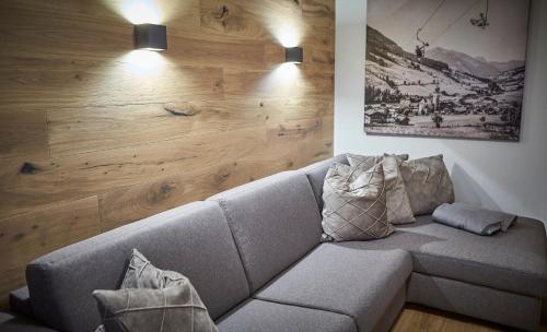 a living room with a couch and a wooden wall at Appartements Der Fuchsbau in Saalbach-Hinterglemm