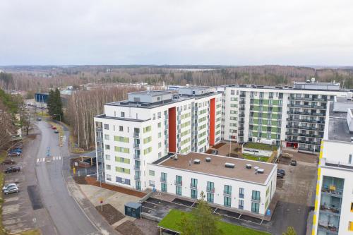 a large white building with a red stripe on it at Hiisi Homes Vantaa Kaivoksela in Vantaa