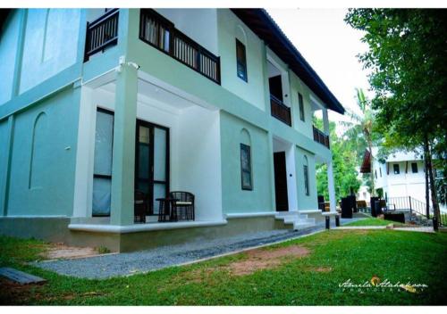 a white building with a yard in front of it at Serendib Signature Resort in Digana