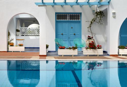 a house with a blue door and a swimming pool at Nikis Village in Poros
