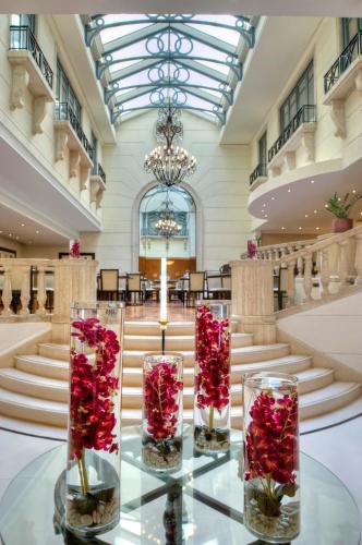 a lobby with three glass vases filled with red roses at Radisson Blu Martinez Beirut in Beirut