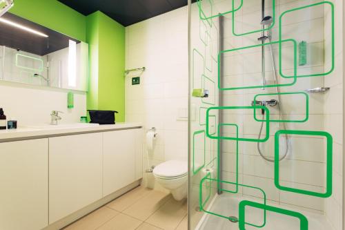 a bathroom with a toilet and a glass shower at harry's home Linz-Urfahr hotel & apartments in Linz