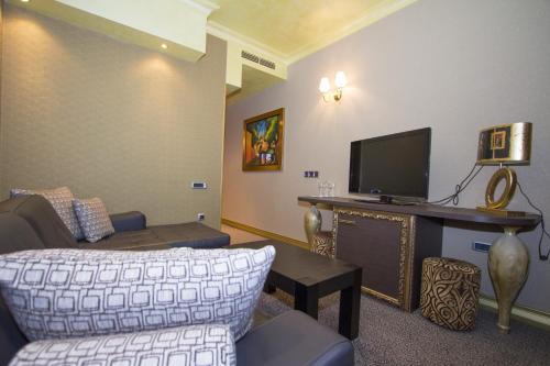 a living room with a couch and a flat screen tv at Hotel Talija in Banja Luka