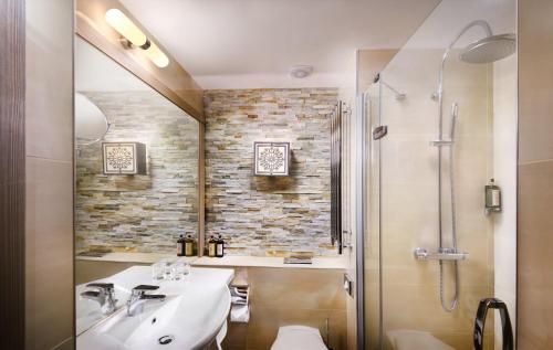 a bathroom with a sink and a shower at Hotel Grand Jasna in Demanovska Dolina