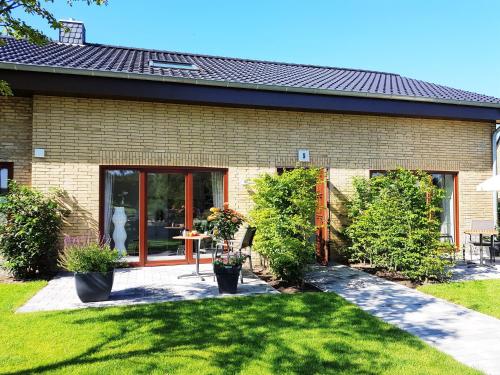 Cette maison dispose d'une terrasse avec une table et des plantes. dans l'établissement Ferienwohnungen am Danewerk, à Dannewerk