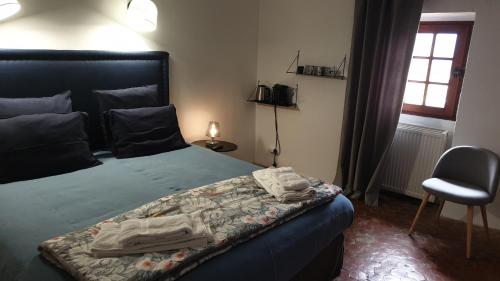 - une chambre avec un lit doté de draps bleus et d'une chaise dans l'établissement la bastide de l'adrech, à Manosque