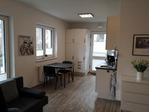 a kitchen and a living room with a table and chairs at Ferienwohnung an der Hasetal-Route in Herzlake