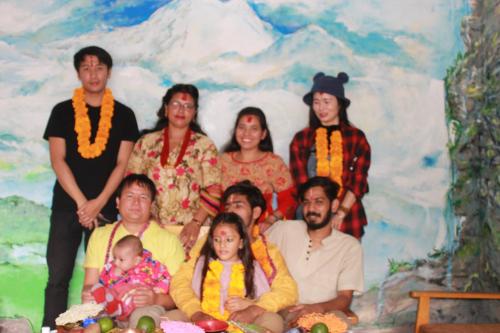 a group of people posing for a picture in front of a painting at Pokhara Metro Eco Hotel in Pokhara