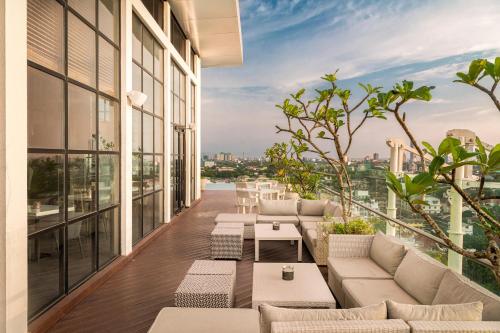 a balcony with couches and tables on a building at Jetwing Colombo Seven in Colombo