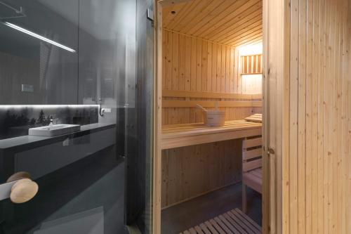 a bathroom with a sink and a wooden wall at Apartament Strumień in Jaworki