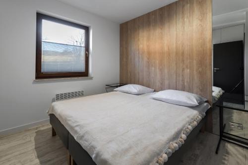 sypialnia z dużym łóżkiem i drewnianą ścianą w obiekcie Apartament Strumień w mieście Jaworki