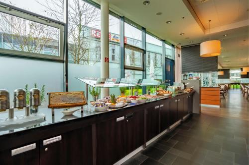 a buffet line with food on display in a restaurant at The Rilano Hotel München in Munich