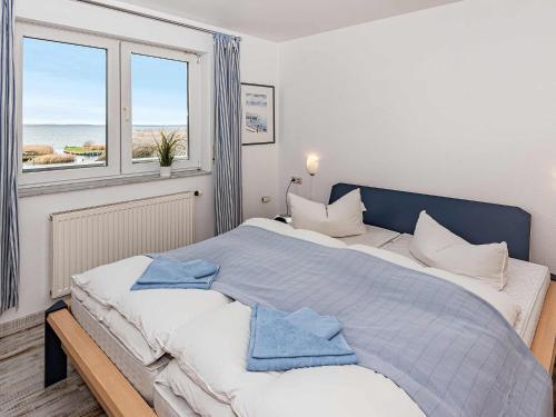 una camera da letto con un grande letto con due asciugamani di Aquarius Ferienwohnung Usedom a Loddin