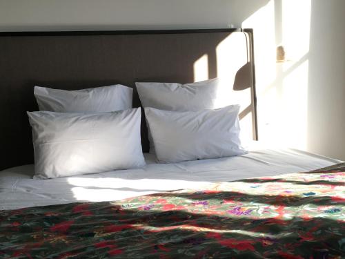a bed with white pillows and a blanket on it at Les Chambres de l'Imprimerie in Beaune