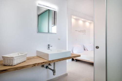 a bathroom with a sink and a mirror and a bed at Villa Arete by PosarelliVillas in Perítheia