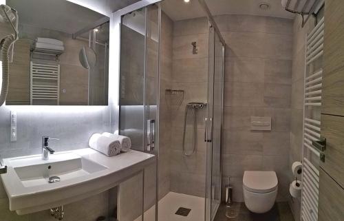 a bathroom with a toilet a sink and a shower at Hotel NERU con Encanto in León