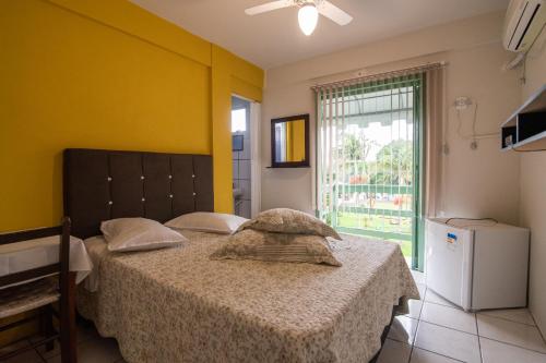 a bedroom with two beds and a window at Hotel Centro dos Canyons in Praia Grande