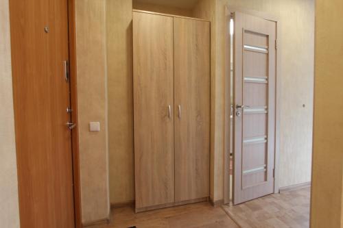 una habitación con 2 armarios de madera y una puerta en Sondeckio Apartment, en Šiauliai