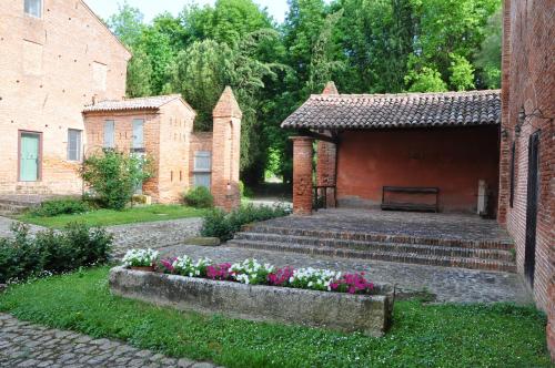 a garden with a bench and flowers in front of a building at BORGO GIUSTINIANI Mora Pero Melo in San Martino di Venezze
