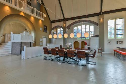 a large room with a table and chairs in it at Church conversion for a unique stay and experience in Rinsumageest
