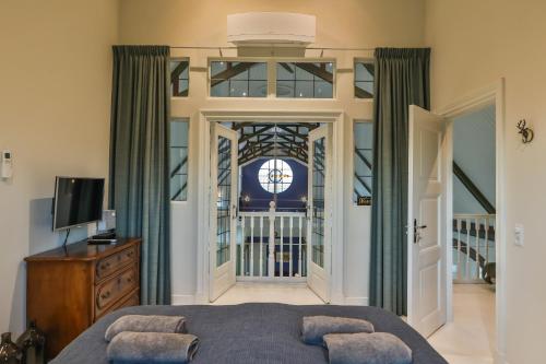 a bedroom with a bed and a door with a window at Church conversion for a unique stay and experience in Rinsumageest