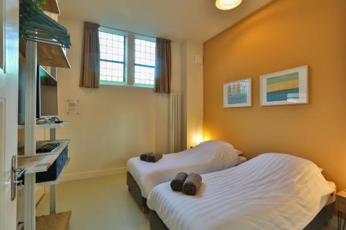 a hospital room with two beds and a sink at Church conversion for a unique stay and experience in Rinsumageest