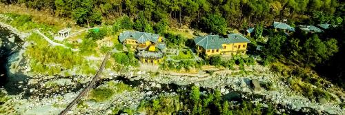 an aerial view of a house on a mountain at Prakriti Aalay - Riverside Mountain View Boutique Eco Resort in Dharamshala