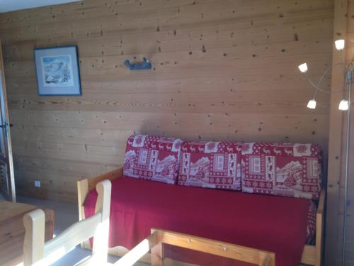 a room with a red couch in a wooden wall at La Vardase in Le Grand-Bornand