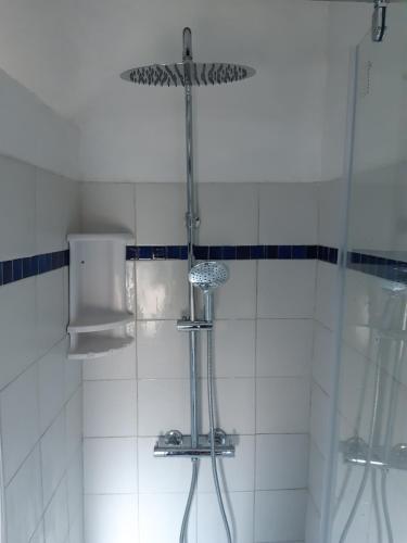 La salle de bains est pourvue d'une douche et de carrelage blanc. dans l'établissement Garden Annexe, à Villeneuve-Loubet