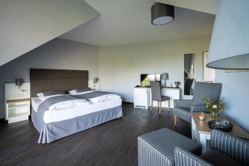 a bedroom with a bed and a table and chairs at Strandhafer Aparthotel in Warnemünde