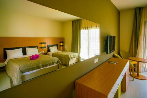 a hotel room with two beds and a television at Hotel Sempati in Kyrenia