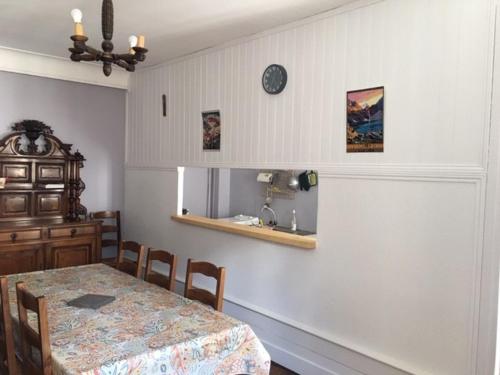 une salle à manger avec une table, des chaises et une horloge dans l'établissement Palais d'étigny, à Luchon