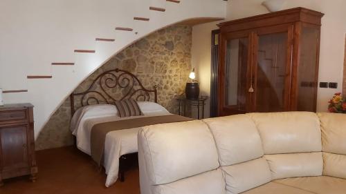 a living room with a bed and a couch at La Limonaia Country House in Monteriggioni