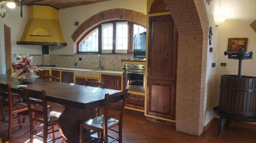 a kitchen with a wooden table and an archway at La Limonaia Country House in Monteriggioni