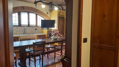 a kitchen and dining room with a table and chairs at La Limonaia Country House in Monteriggioni