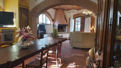 a kitchen with a large wooden table and a dining room at La Limonaia Country House in Monteriggioni