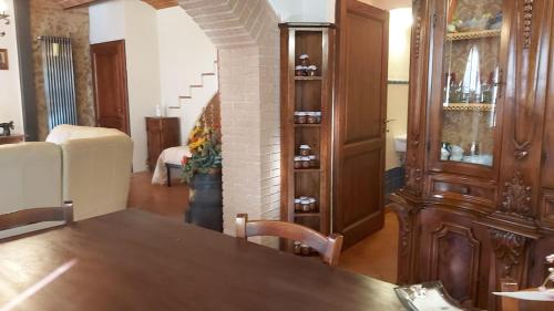 a dining room with a table and a room with a couch at La Limonaia Country House in Monteriggioni