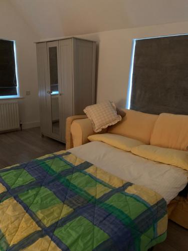 a living room with a couch and a bed at Appletree Cottages in Mildenhall