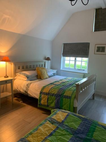 a bedroom with two beds and a window at Appletree Cottages in Mildenhall