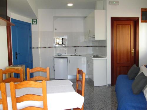 une petite cuisine avec une table et un canapé dans l'établissement Apartamento Terranova Esquina Placeta, à Alhama de Granada