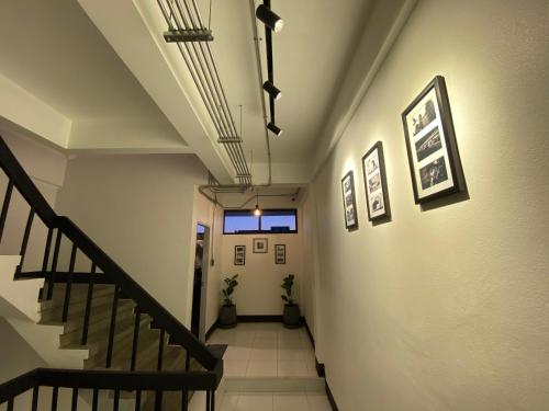 a hallway with stairs and pictures on the walls at Backpack Hostel in Chiang Rai