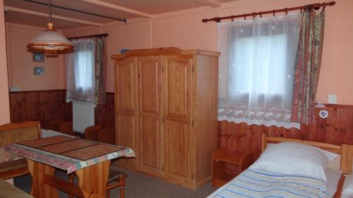 um quarto com uma cama, um armário e uma mesa em osada yukon em Tři Studně