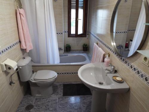 a bathroom with a toilet and a sink and a tub at Casa de campo cerca del mar in Miengo