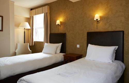 A bed or beds in a room at Ye Olde Talbot Hotel by Greene King Inns 