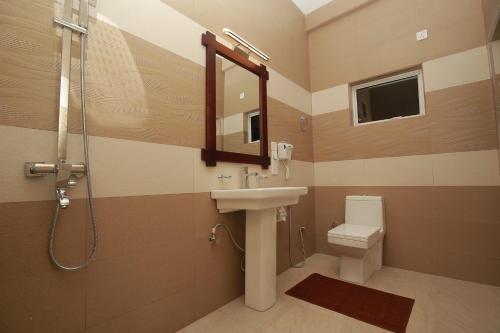 a bathroom with a sink and a shower and a toilet at Hotel River Front in Tissamaharama