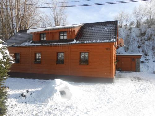 a wooden house in the snow with snow at Chalupa Nella in Velké Karlovice