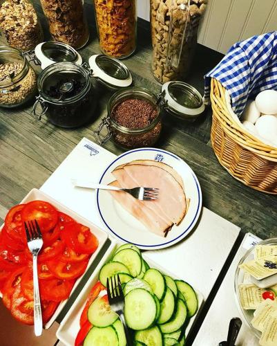 a table with plates of food with vegetables and meat at Karlshamn Vandrarhem och Hotell in Karlshamn