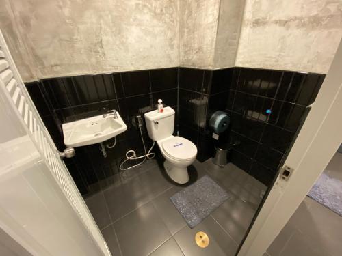 a small bathroom with a toilet and a sink at Backpack Hostel in Chiang Rai