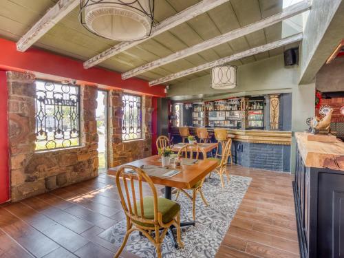 comedor con paredes rojas, mesa y sillas en Gran Hotel Campestre, en Celaya