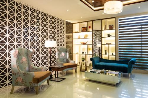 a lobby with chairs and a couch and a table at After Hours Residence in Dhaka